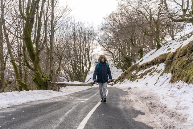 Fotógrafo caminando por un camino nevado disfrutando de la fotografía de invierno