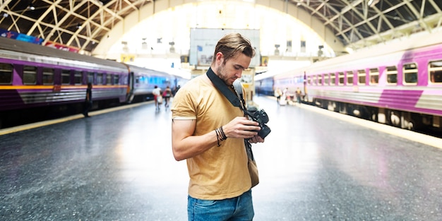 Foto fotógrafo caucásico en la estación de tren.