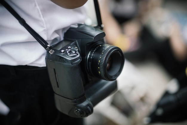 Foto fotógrafo colgando una cámara dslr en el hombro concepto de fotografía fotógrafo profesional