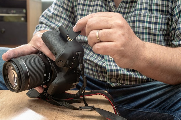 Fotógrafo colocando una tarjeta de memoria SD en una cámara fija profesional