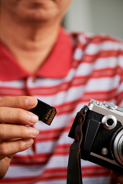 Fotógrafo com câmera e cartão de memória