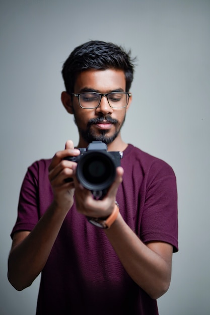 Fotógrafo com câmera em fundo branco.