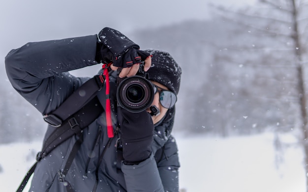 Fotógrafo com fundo de neve caindo