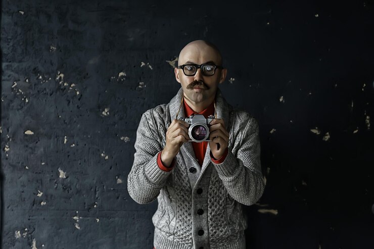 Foto fotógrafo com uma câmera analógica vintage, um homem com bigode, imagem engraçada aprendendo fotografia