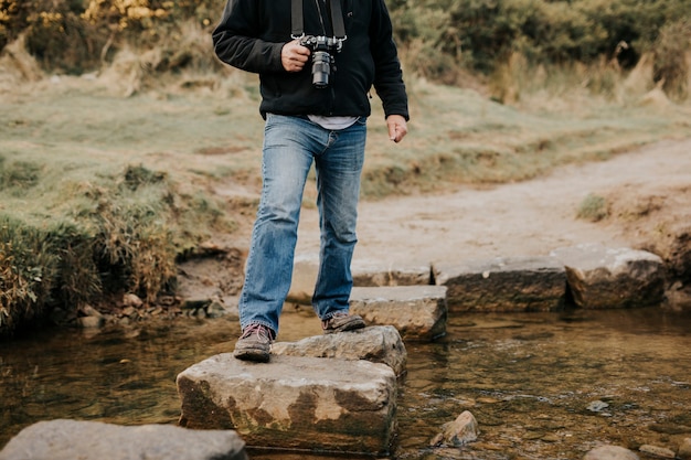 Fotógrafo cruzando el agua por un escalón