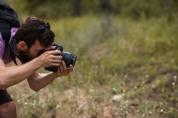 Foto fotógrafo da natureza. homem com câmera na floresta. desejo de viajar e estilo de vida de viagens