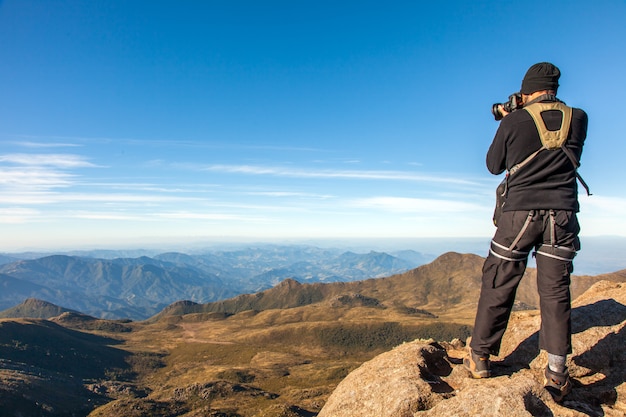 Fotógrafo de alpinista fotografar paisagem no cume da montanha