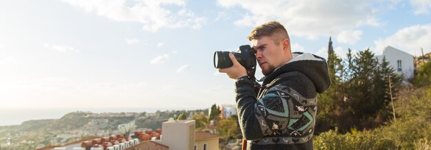 Fotógrafo de férias de viagens e viajante do conceito de carona homem fotografou montanhas e cidades