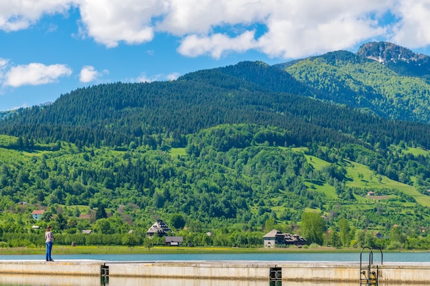 Foto fotógrafo de menina bonita andando em um lago de montanha