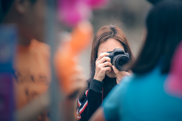 Fotógrafo de mulher segurando a câmera dslr tirando fotos