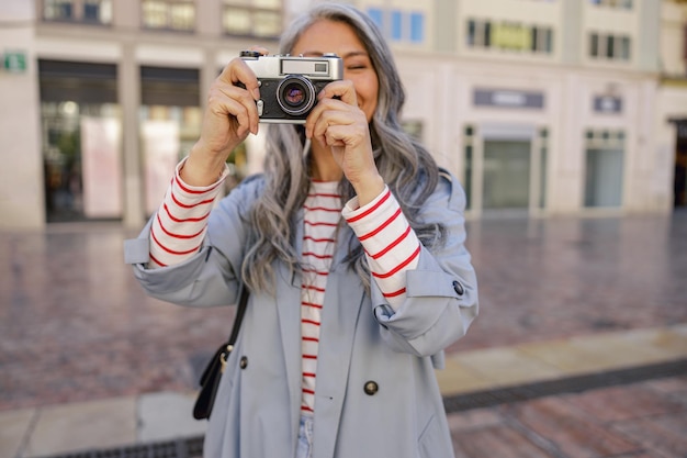 Fotógrafo de mulher tirando foto no centro da cidade