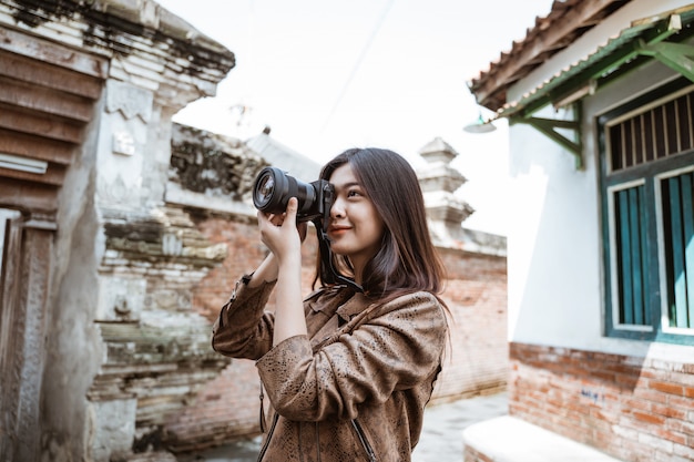 Fotógrafo de mulher tirando foto usando a câmera