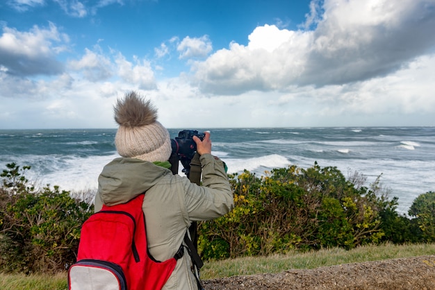 Fotógrafo de mulher trabalhando durante uma tempestade em Biarritz França