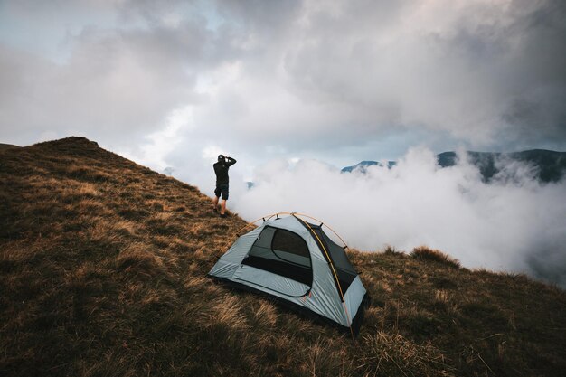 Fotógrafo de pé perto da tenda nas altas montanhas Fagaras montanhas Romênia