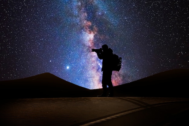 Foto fotógrafo en el desierto con la vía láctea