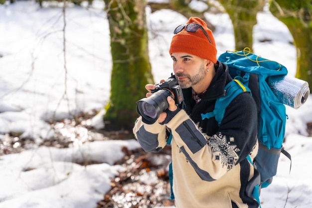 Fotógrafo disfrutando tomando fotos en invierno en un bosque nevado