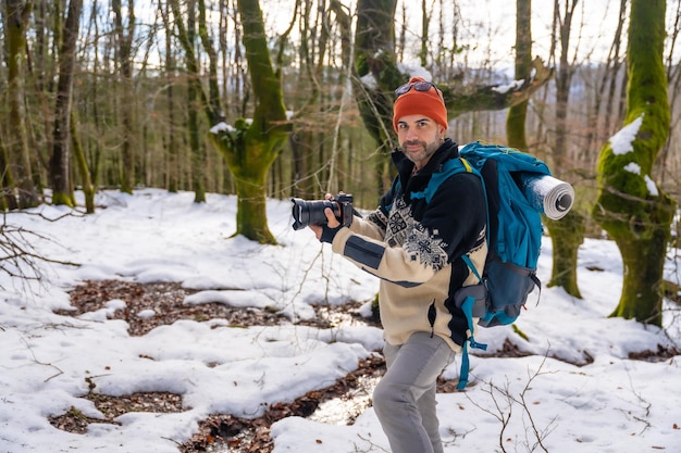 Fotógrafo disfrutando tomando fotos en invierno en un bosque nevado