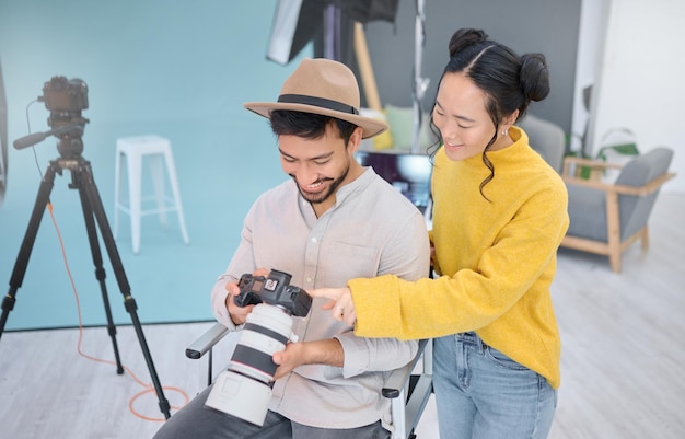 Fotógrafo e modelo de fotografia em discussão com uma câmera escolhendo uma imagem da sessão de fotos Arte criativa e jovem cinegrafista conversando com a mulher para escolher a melhor foto no estúdio artístico