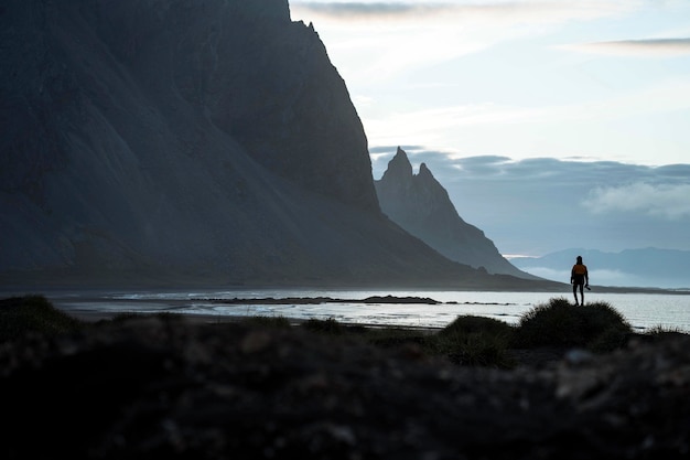 Fotógrafo em uma colina verde na península de Stokksnes, no sudeste da Islândia