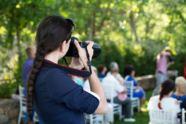 El fotógrafo es una mujer que fotografía una ceremonia de boda