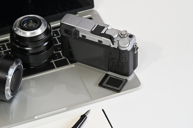 Fotógrafo de escritorio con cámara, lente, laptop y memoria.