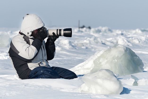 El fotógrafo está fotografiando con teleobjetivo en el hielo del Ártico.