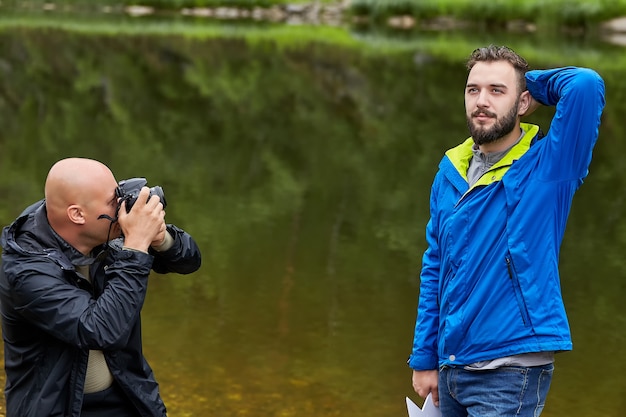 El fotógrafo está tomando fotografías de modelo masculino en la naturaleza.