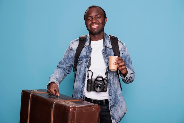 Fotógrafo feliz con equipaje y cámara DSLR preparándose para el viaje de vacaciones. Entusiasta de la fotografía alegre con dispositivo fotográfico y equipaje en un viaje de viaje de fin de semana.