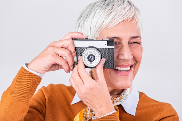 Fotógrafo feminino maduro, tirando fotos com a câmera retro velha.