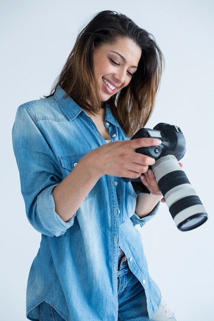 Fotógrafo feminino revendo fotos capturadas em sua câmera digital