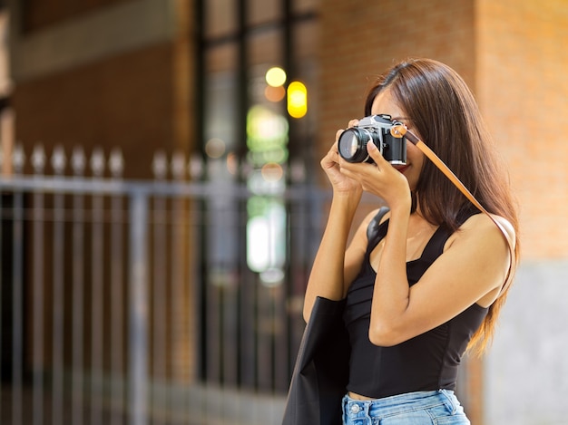 Fotógrafo freelance femenino tomando fotografías con cámara de película en viaje solo de vacaciones