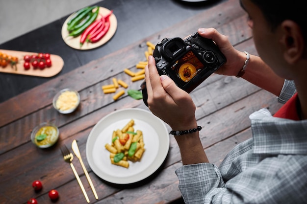 Foto fotógrafo haciendo fotos de comida en cámara.