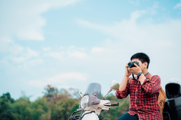 Fotógrafo hipster andando de motoneta na estrada Viajou de scooter vida lenta no tempo de descanso de férias