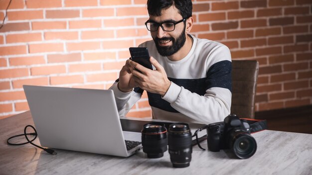 Fotógrafo homem mão telefone com lente na mesa