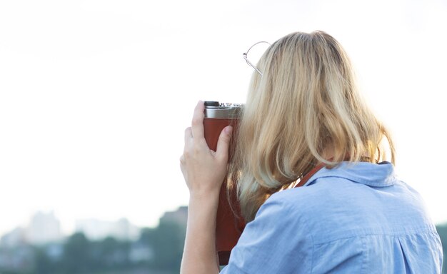 Fotógrafo joven inconformista joven en vestido azul tomando fotografías en una cámara de película vintage. Espacio vacio