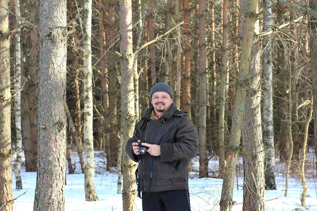 Fotógrafo masculino en el bosque de invierno