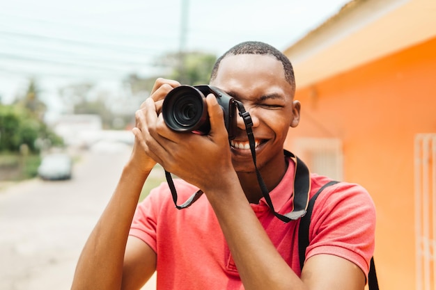 Fotógrafo masculino con estilo joven con cámara mientras explora la ciudad