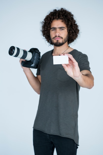 Fotógrafo masculino mostrando o cartão de visita no estúdio