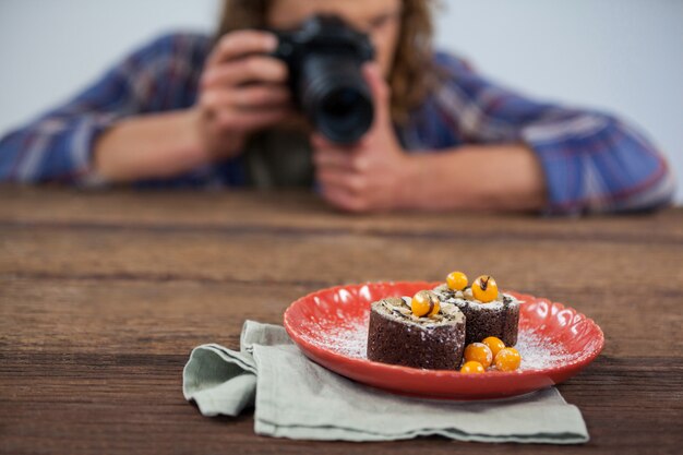 Foto fotógrafo masculino que fotografa o alimento