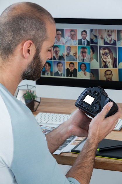 Fotógrafo masculino revisando fotos capturadas en su cámara digital