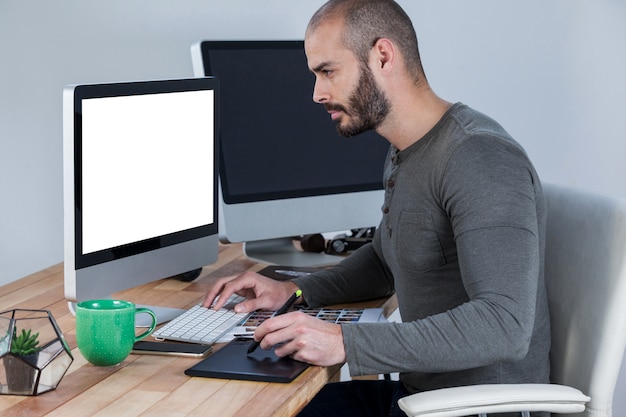 Fotógrafo masculino con tableta gráfica en el escritorio