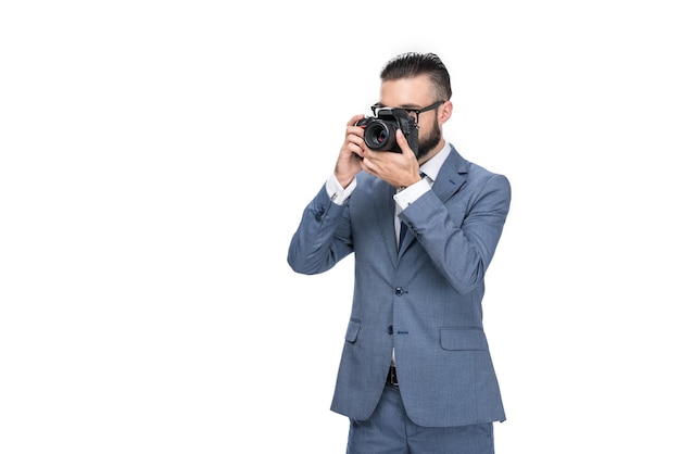 Fotógrafo masculino tomando fotos en una cámara profesional aislada en blanco
