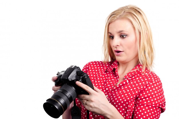 Fotógrafo de mujer bonita rubia con su cámara, en blanco