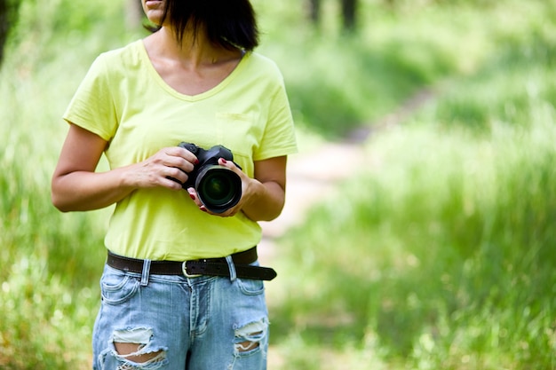 Fotógrafo de mujer con una cámara de fotos en la mano al aire libre