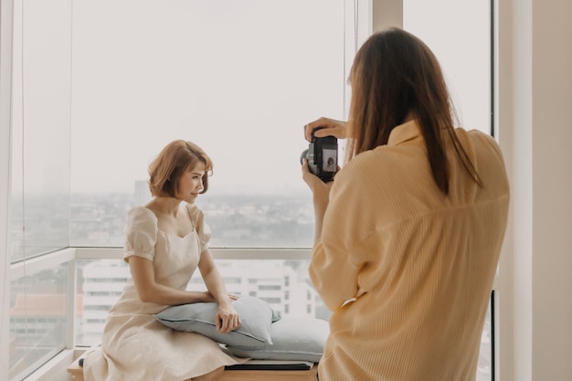 Fotógrafo de mujer está tomando una foto de su modelo de moda mujer