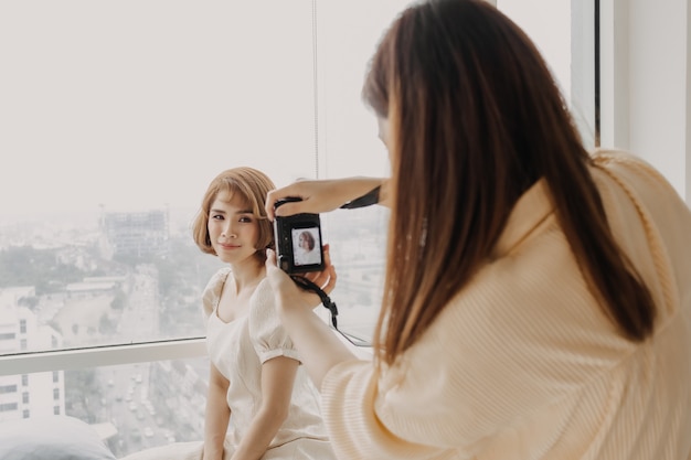 Fotógrafo de mujer está tomando una foto de su modelo de moda mujer