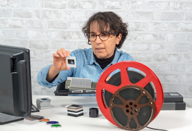 Fotógrafo de mujer mirando diapositiva de película