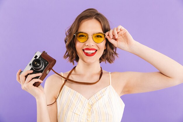 Fotógrafo de mujer posando aislado sosteniendo la cámara.