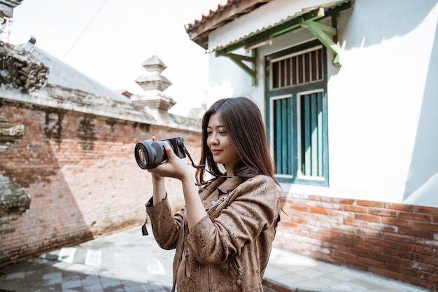 Fotógrafo de mujer tomando foto con cámara