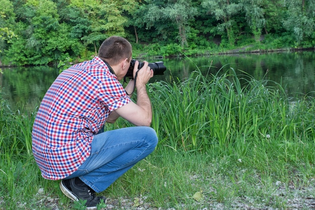 Foto fotógrafo na margem do rio